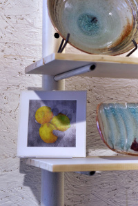 Decorative picture frame on a shelf with pottery
